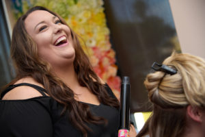 member laughing while doing hair in her suite