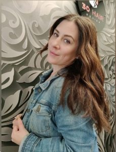 Doreen posing in her suite in front of the wallpaper