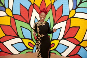 MY SALON Suite Member Latoya standing in front of mural