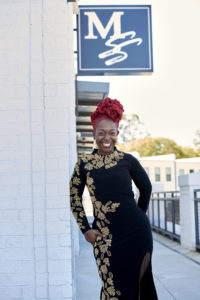 Latoya standing in front of the MSS sign in a black dress