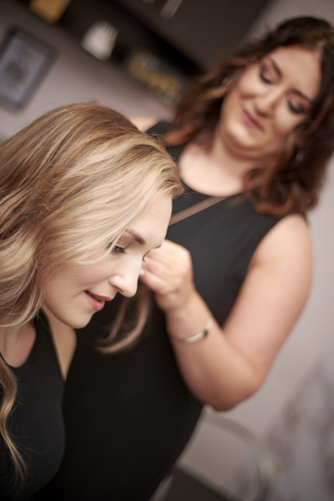 A photo of a Suite Elite Member styling a client's hair