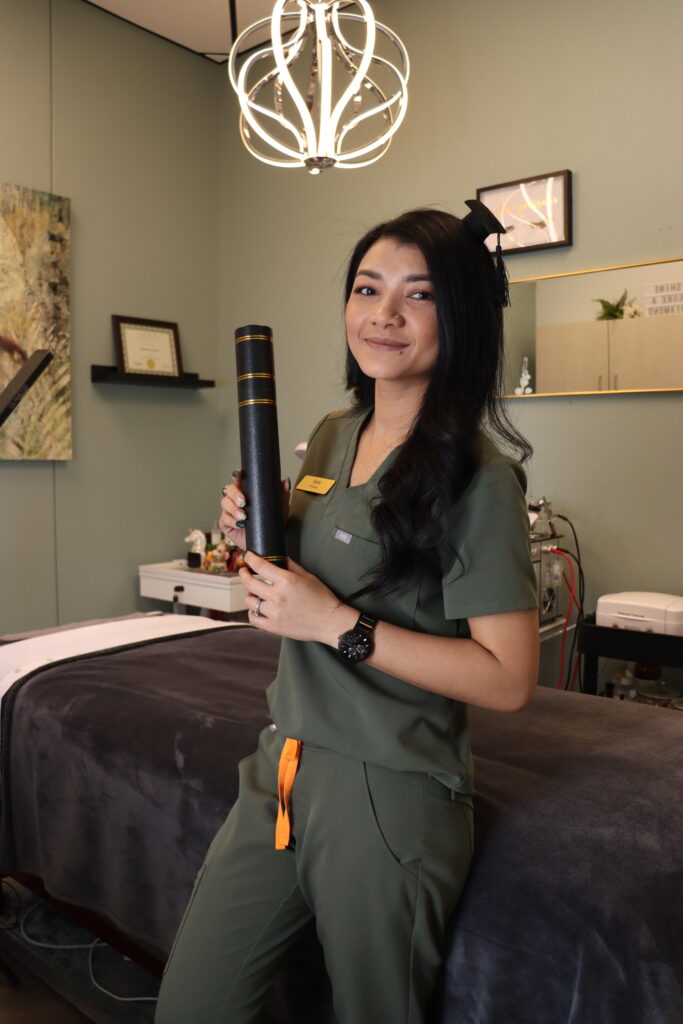 Suite Elite Member wearing a tiny graduation hat and holding a diploma